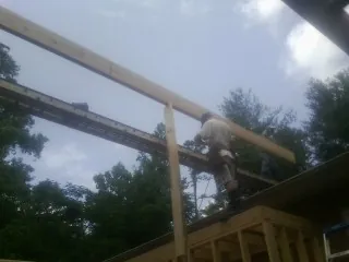 Carpenter setting a ridge beam over a new addition frame — Ice Dam Removal by Roofing Brothers in Henning